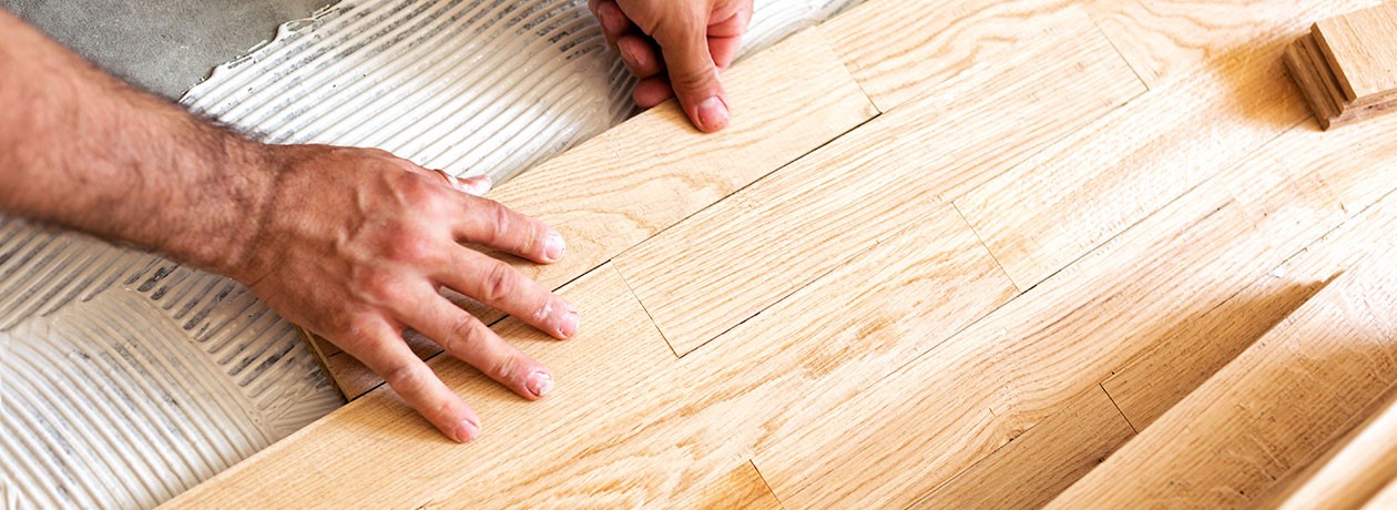 Individual installing wood flooring.