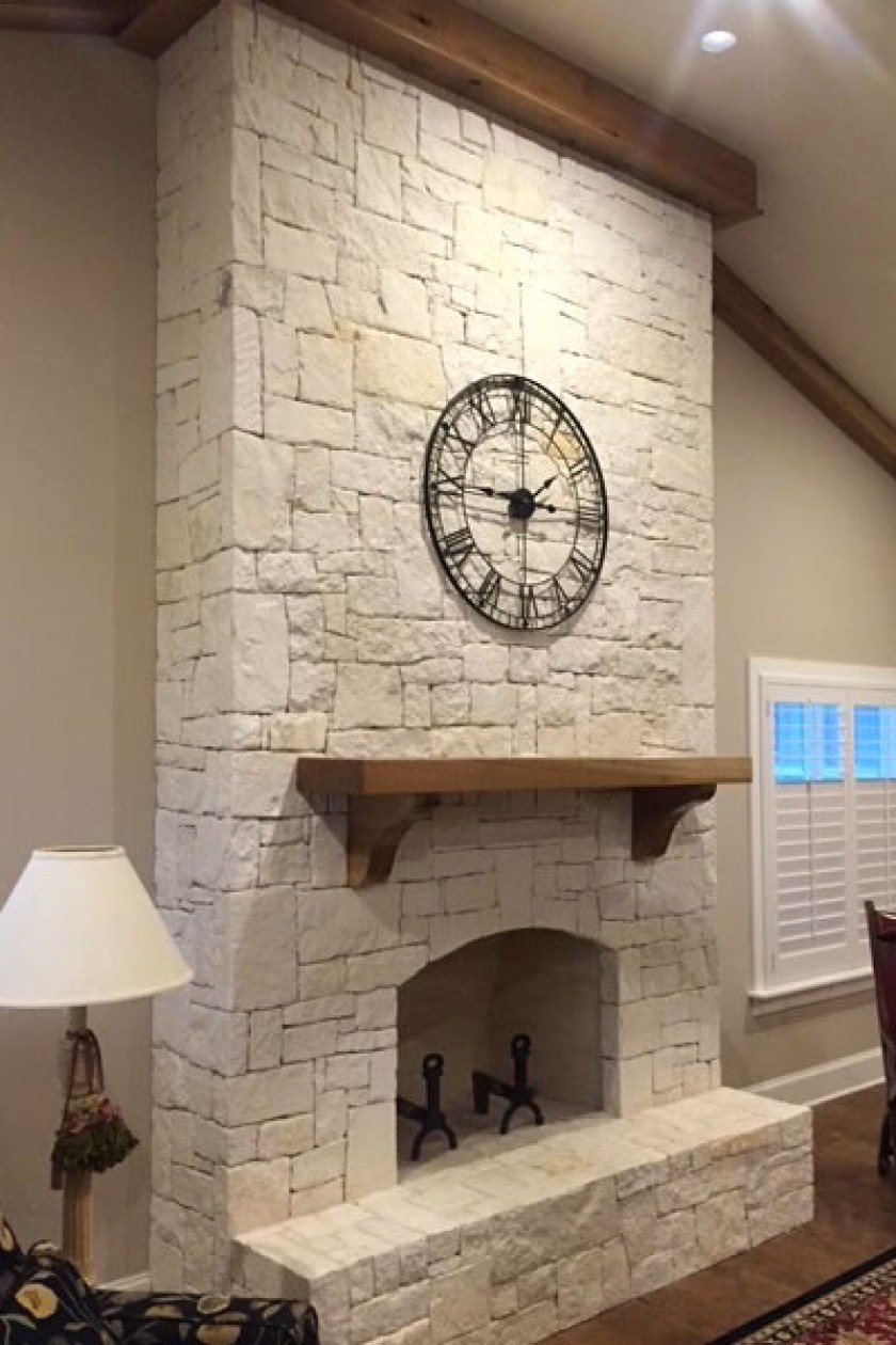 White stone fireplace in a living room.