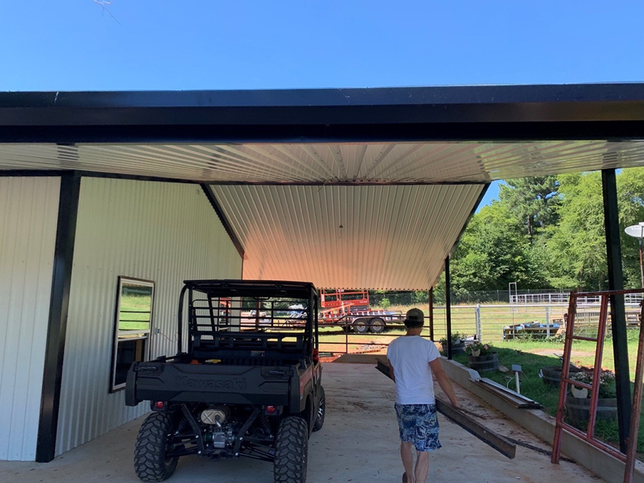 Residential metal building with roof overhang.